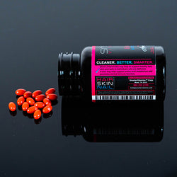 Bottle of Smarter Biotin vitamin B7 laying on a table with supplements poured out onto a table