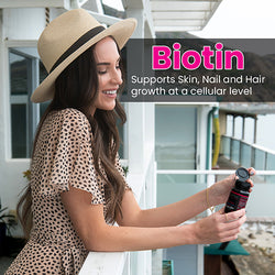 Woman looking over a balcony holding a bottle of Smarter Biotin